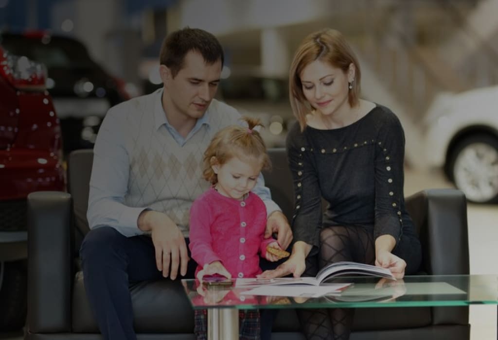 Семья выбирает новый автомобиль в автосалоне по программе льготного автокредитования 2025 года